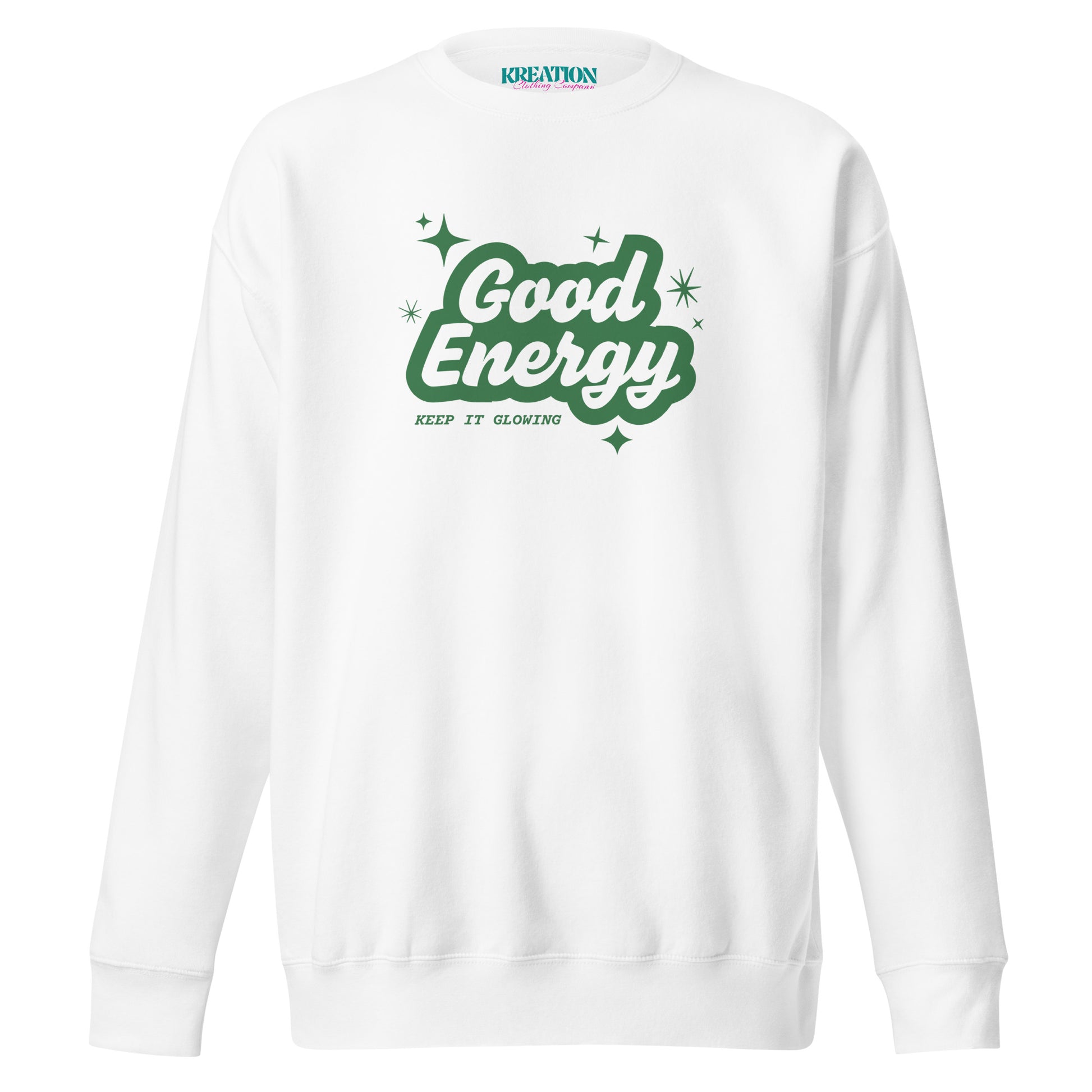 A white crewneck sweatshirt featuring a green graphic on the chest that reads 'Good Energy' in a retro bubble font with small star accents, and 'KEEP IT GLOWING' printed below. The neck label shows the brand 'KREATION.